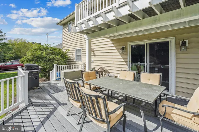 a view of a patio with table and chairs with wooden floor and fence