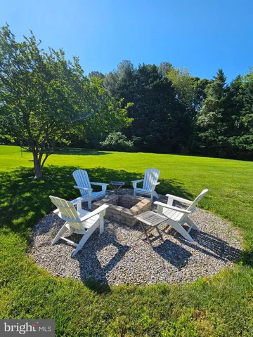 a view of a swimming pool and lounge chairs in back yard