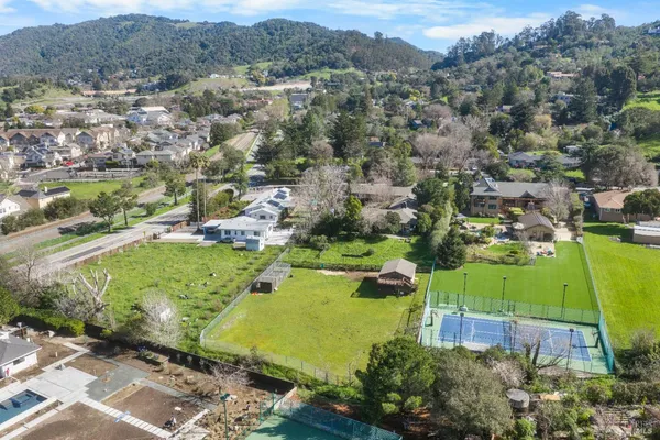 an aerial view of a houses with a lush green hillside