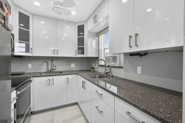 a kitchen with granite countertop a sink stainless steel appliances and cabinets