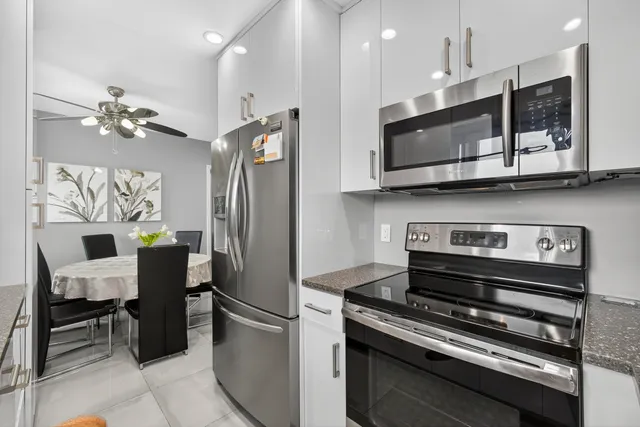 a kitchen with stainless steel appliances granite countertop a stove refrigerator and microwave