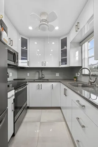 a large kitchen with stainless steel appliances granite countertop a sink and a stove