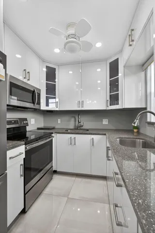 a kitchen with stainless steel appliances granite countertop a sink and a stove