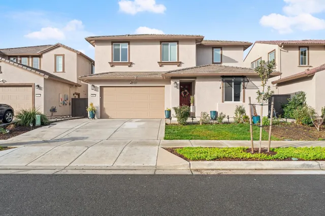a front view of a house with a garden and plants