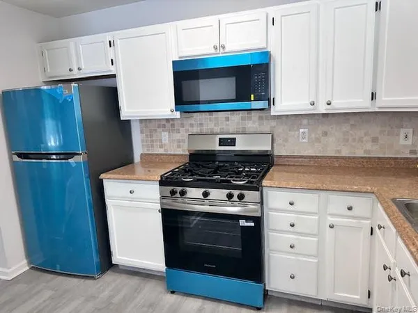 a kitchen with stainless steel appliances a stove a microwave and a refrigerator
