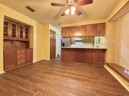 a view of a kitchen with cabinets and wooden floor