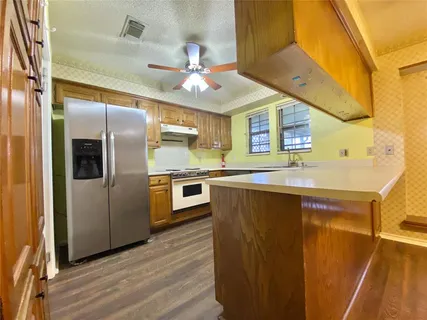 a kitchen with stainless steel appliances granite countertop a sink and a refrigerator