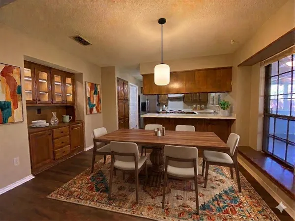 a view of a dining room and livingroom with furniture wooden floor a rug and a chandelier
