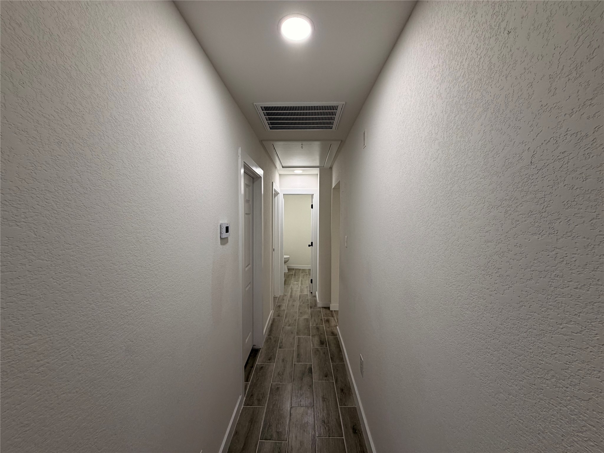 5842 Beldart Street Houston, TX 77033 - Photo 11 of 24 a view of a hallway with wooden floor
