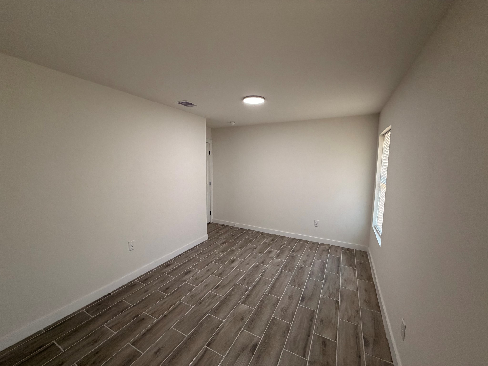 5842 Beldart Street Houston, TX 77033 - Photo 17 of 24 a view of an empty room with wooden floor