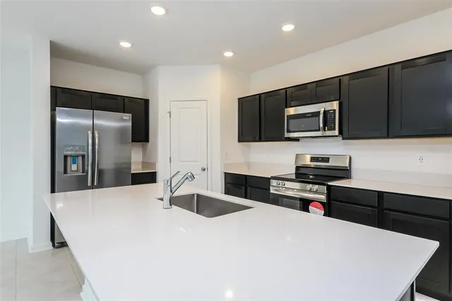 a kitchen with stainless steel appliances a stove sink microwave and cabinets