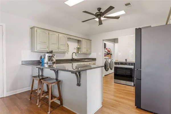 a kitchen with stainless steel appliances granite countertop a stove a refrigerator and a refrigerator