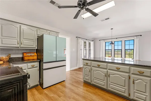 a large kitchen with stainless steel appliances granite countertop a stove and cabinets