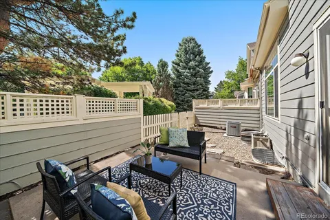a view of a patio with wooden chairs