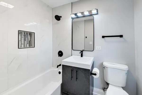 a bathroom with a sink toilet vanity and tub