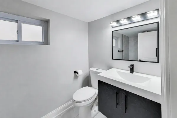 a bathroom with a toilet sink and mirror