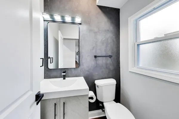 a bathroom with a toilet a sink and a mirror