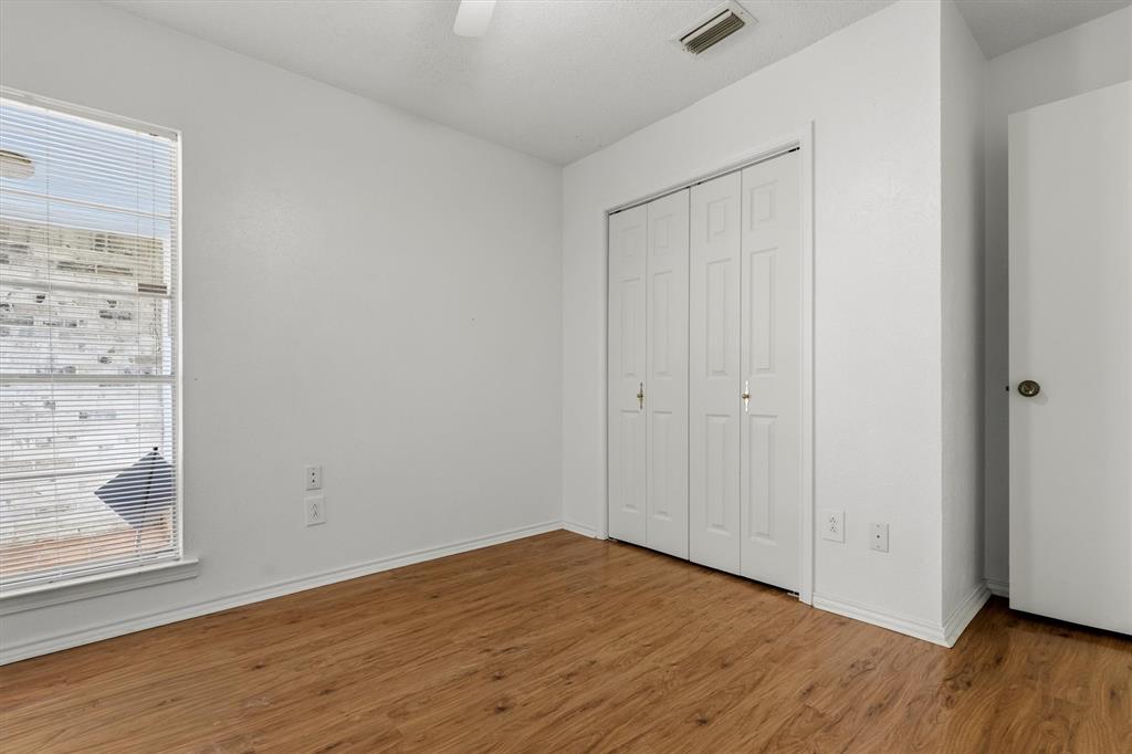 1817 Indian School Road Garland, TX 75044 - Photo 11 of 40 Unfurnished bedroom featuring wood finished floors, a closet, and a ceiling fan
