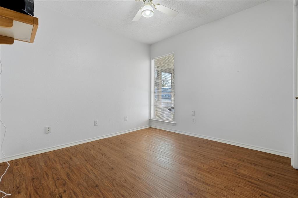 1817 Indian School Road Garland, TX 75044 - Photo 13 of 40 Empty room featuring wood finished floors, a textured ceiling, and a ceiling fan