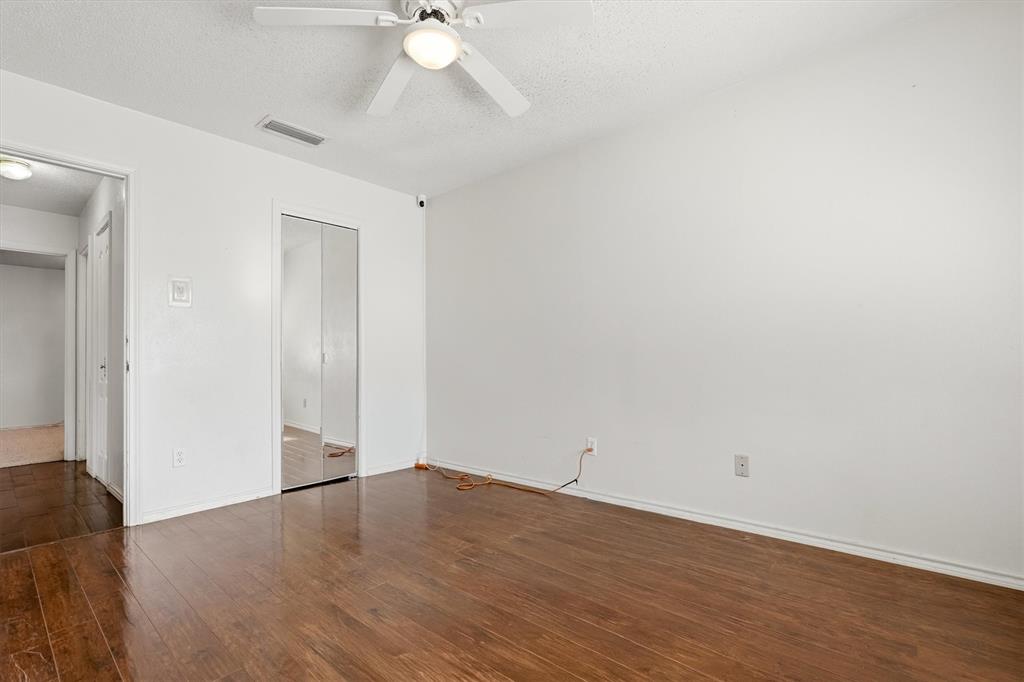 1817 Indian School Road Garland, TX 75044 - Photo 14 of 40 Unfurnished bedroom with dark wood-style flooring, a textured ceiling, ceiling fan, and a closet