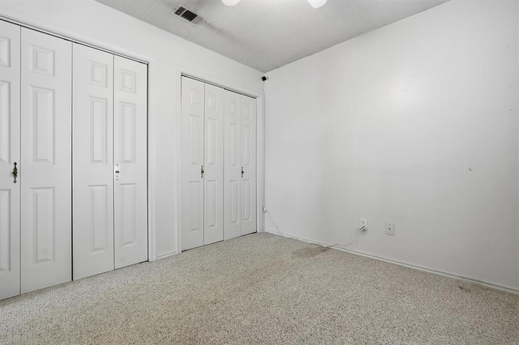 1817 Indian School Road Garland, TX 75044 - Photo 16 of 40 Unfurnished bedroom featuring two closets and ceiling fan