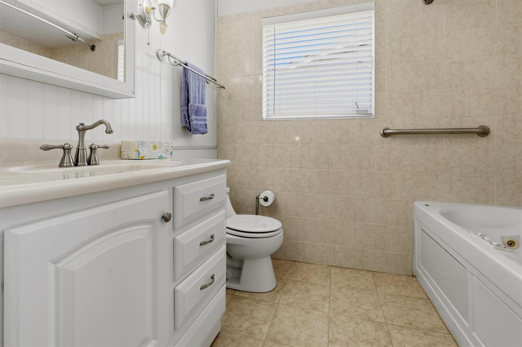 1817 Indian School Road Garland, TX 75044 - Photo 20 of 40 Bathroom featuring vanity, light tile patterned floors, and tile walls