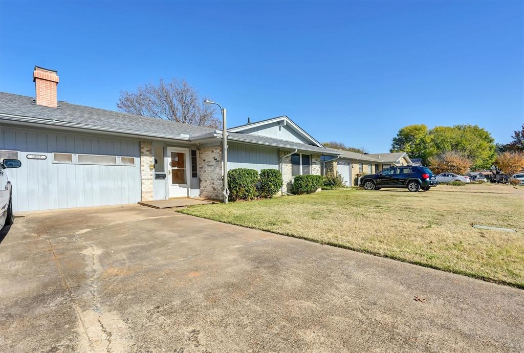 1817 Indian School Road Garland, TX 75044 - Photo 2 of 40 Ranch-style home featuring a front lawn, driveway, a chimney, a shingled roof, and brick siding