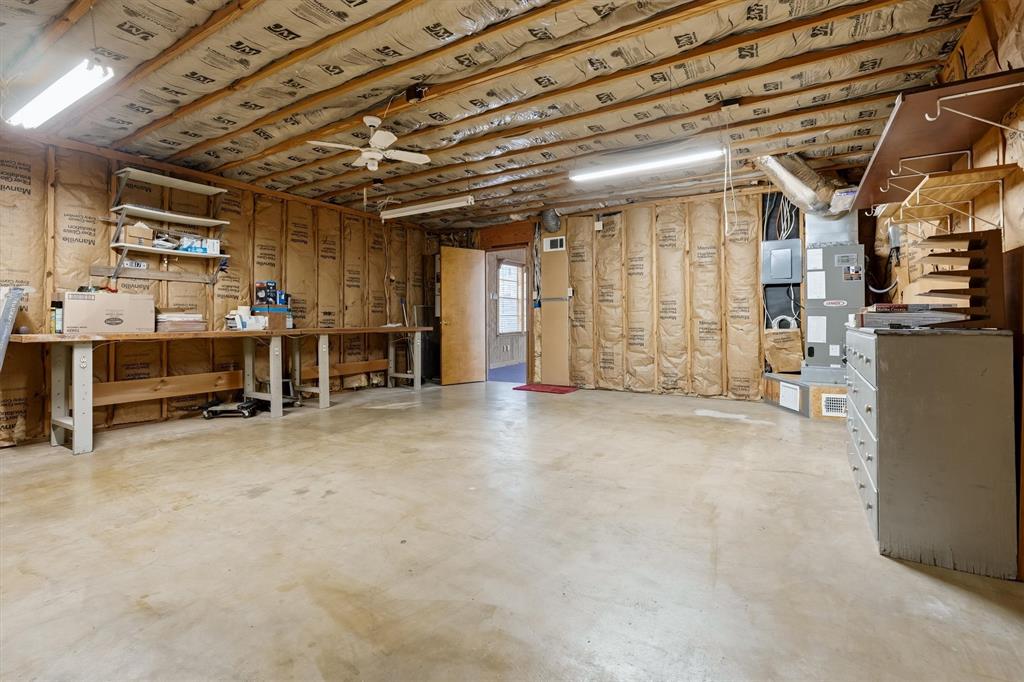1817 Indian School Road Garland, TX 75044 - Photo 34 of 40 Below grade area with a workshop area, electric panel, and heating unit