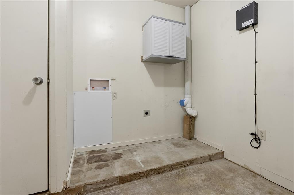 1817 Indian School Road Garland, TX 75044 - Photo 35 of 40 Washroom with unfinished concrete floors, electric dryer hookup, washer hookup, and cabinet space