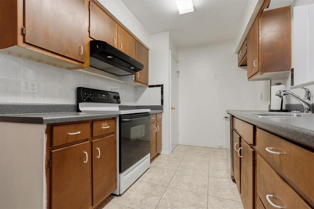 1817 Indian School Road Garland, TX 75044 - Photo 8 of 40 Kitchen with range with electric stovetop, extractor fan, dark countertops, brown cabinets, and backsplash