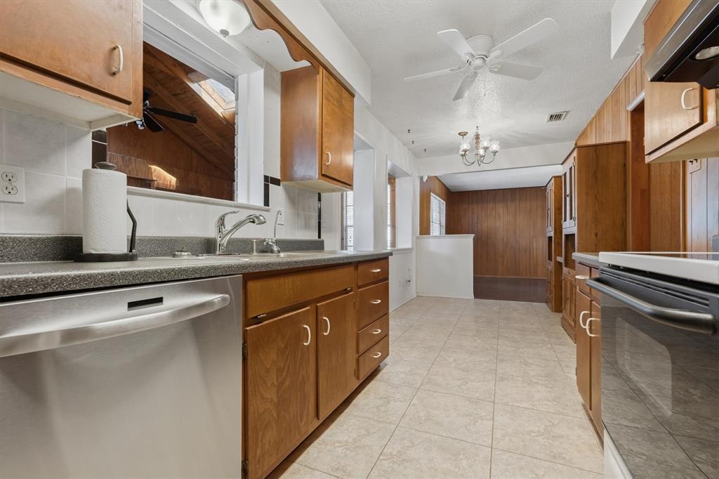 1817 Indian School Road Garland, TX 75044 - Photo 9 of 40 Kitchen featuring ceiling fan, stainless steel dishwasher, black / electric stove, brown cabinets, and extractor fan