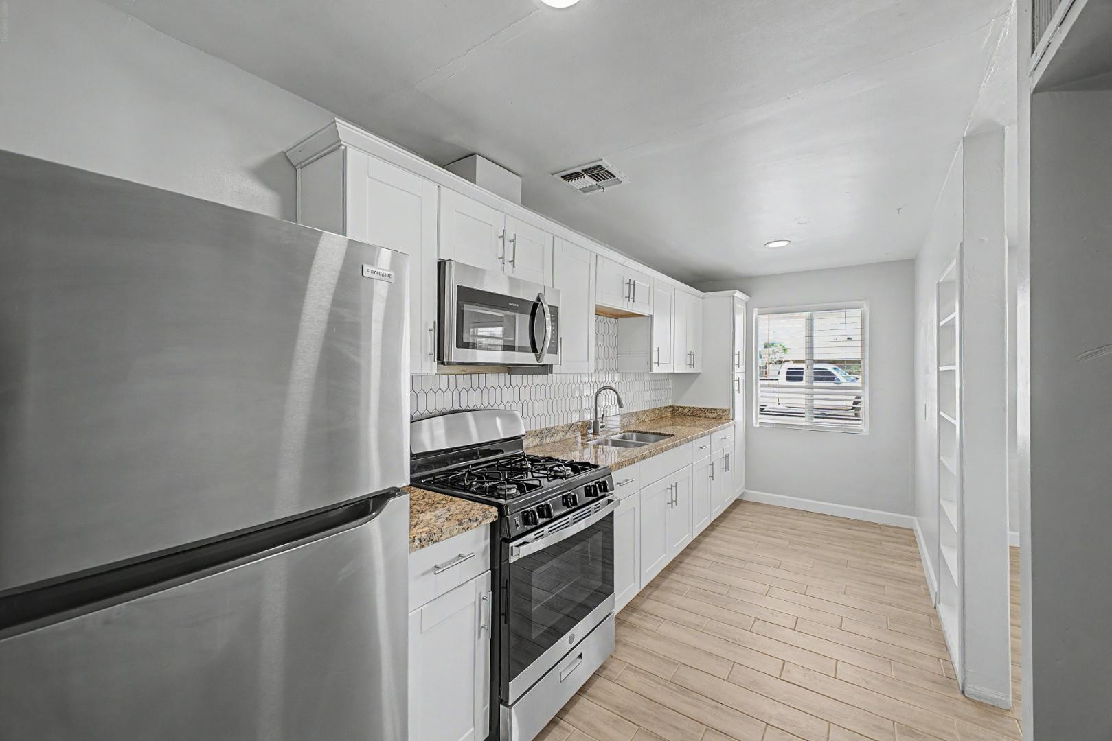 2534 North 28th Street Phoenix, AZ 85008 - Photo 1 of 33 a kitchen with stainless steel appliances a refrigerator a stove and white cabinets