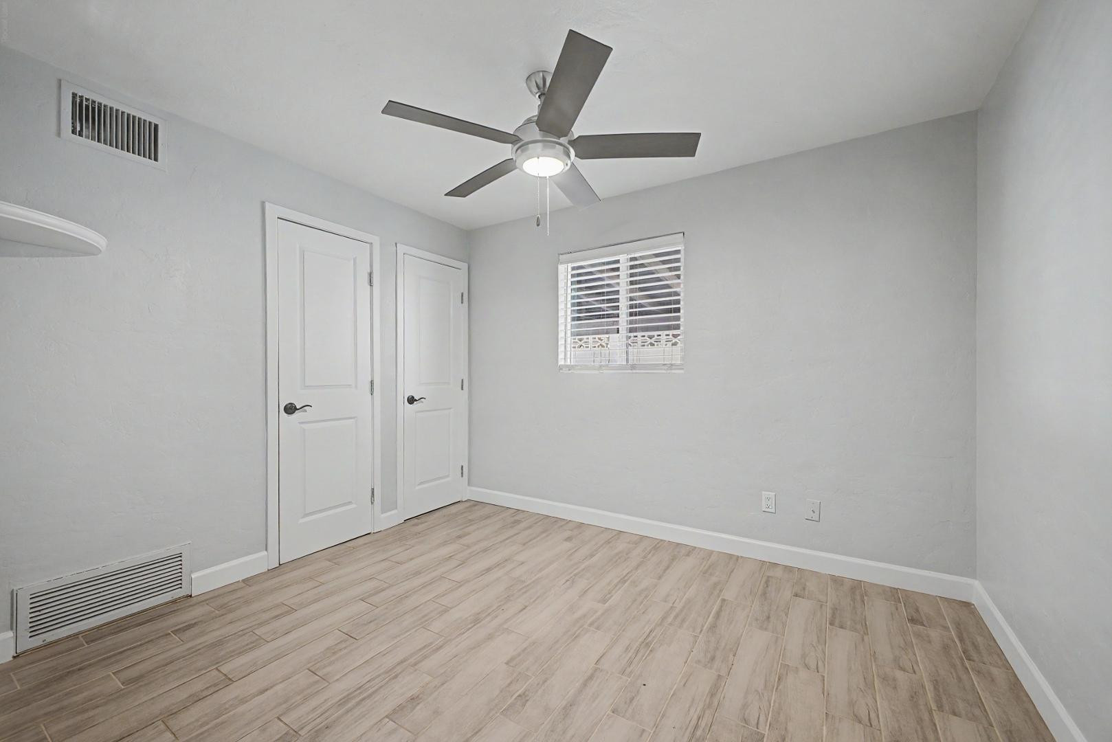 2534 North 28th Street Phoenix, AZ 85008 - Photo 18 of 33 an empty room with wooden floor fan and windows