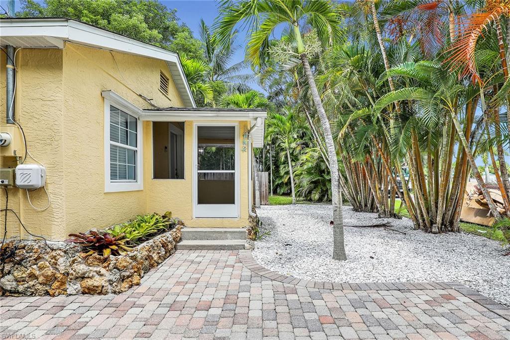 2780 Weeks Avenue Naples, FL 34112 - Photo 30 of 34 a front view of a house with a yard and potted plants