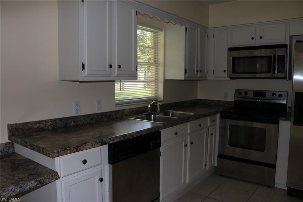 19177 Acorn Road Fort Myers, FL 33967 - Photo 14 of 24 a kitchen with granite countertop white cabinets sink and stainless steel appliances