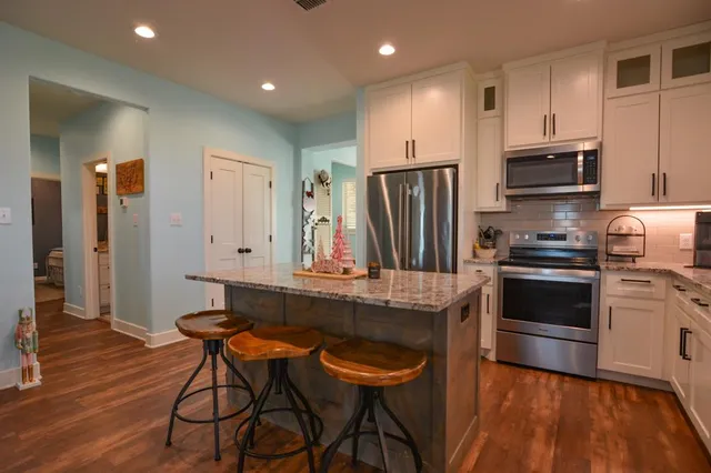a kitchen with stainless steel appliances a refrigerator and a stove top oven
