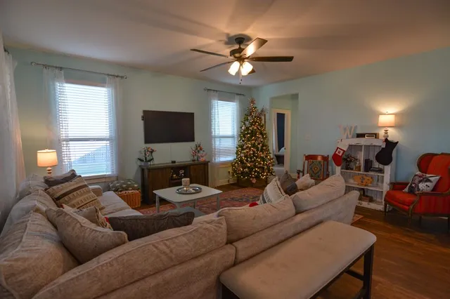 a living room with furniture a flat screen tv and a window