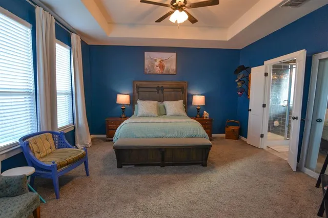 a bedroom with a bed chair and a large window