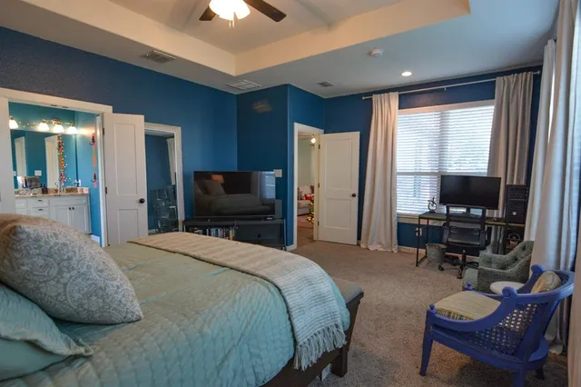 a spacious bedroom with a bed and a flat screen tv