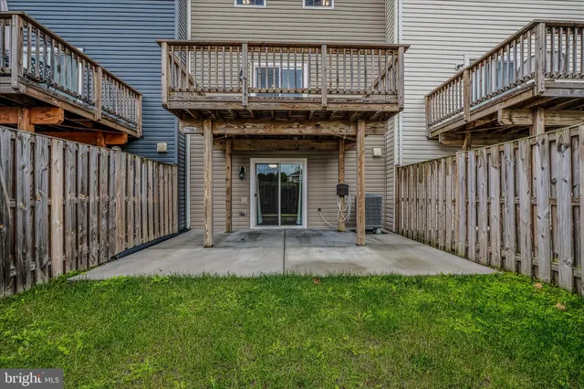 a view of a backyard with plants and wooden fence