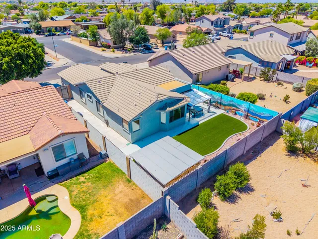 an aerial view of a house with swimming pool and outdoor seating