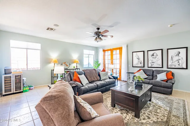 a living room with furniture a ceiling fan and a window