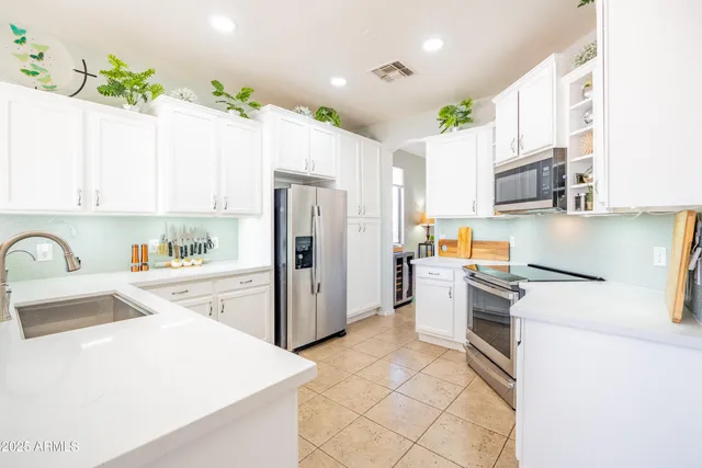 a kitchen with a sink a refrigerator and a stove top oven