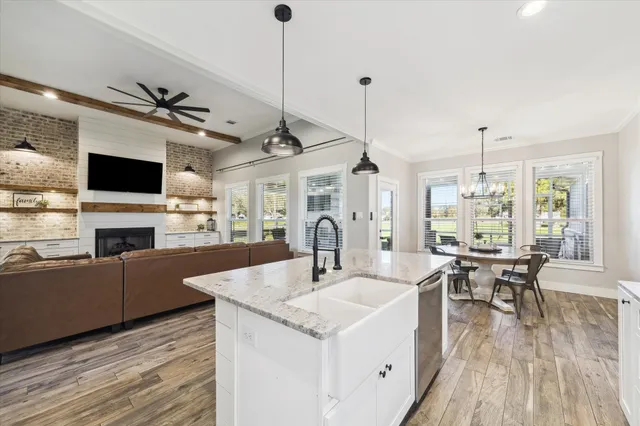a view of a dining room and livingroom with furniture wooden floor a chandelier