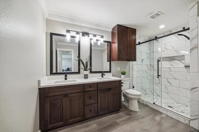 a bedroom with a bed and dresser with mirror