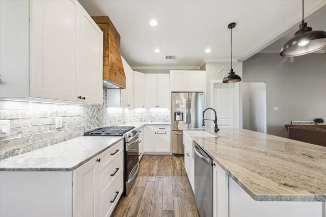 a large kitchen with kitchen island a large counter space a sink appliances and cabinets