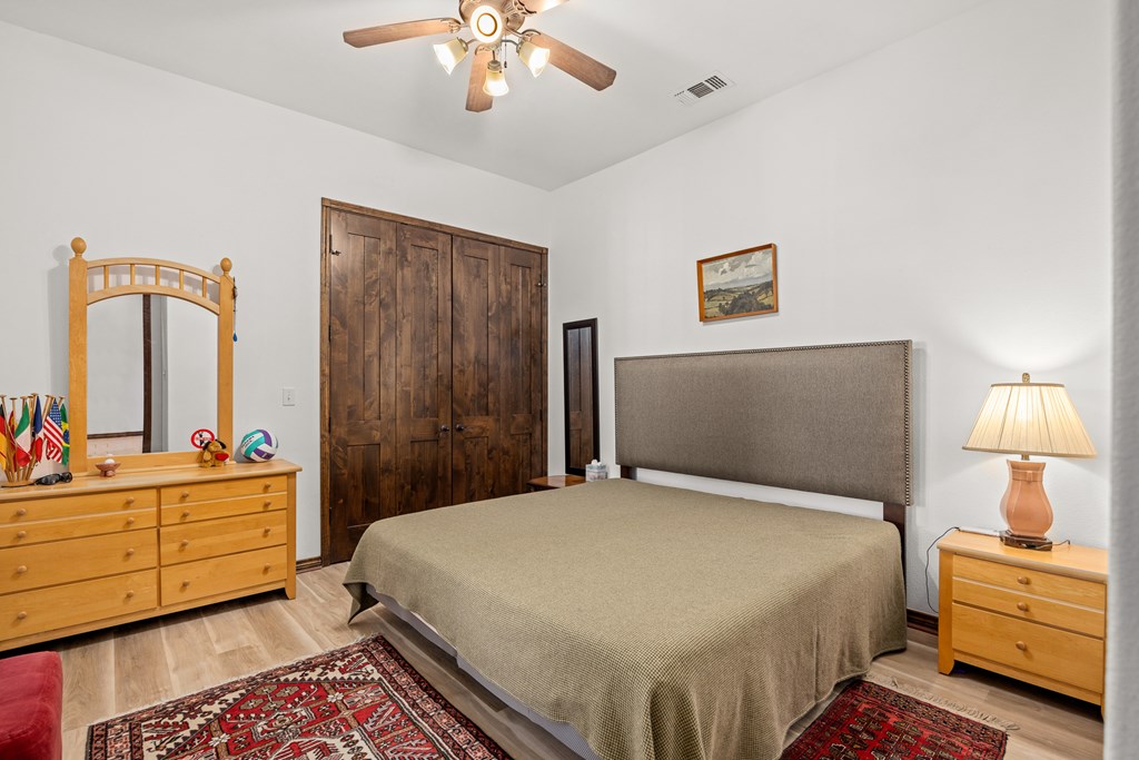 3801-12 Club House Road Kerrville, TX 78028 - Photo 12 of 23 a bedroom with a bed and a chandelier