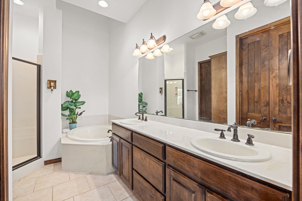 3801-12 Club House Road Kerrville, TX 78028 - Photo 15 of 23 a bathroom with a double vanity sink a mirror and a bathtub