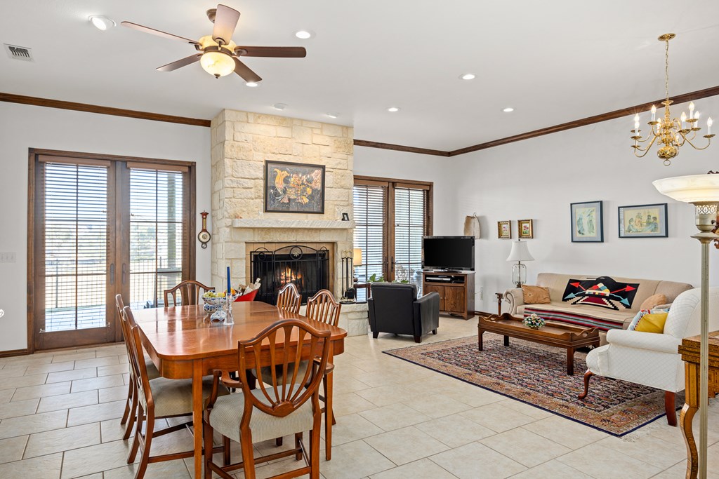 3801-12 Club House Road Kerrville, TX 78028 - Photo 5 of 23 a dining room with furniture a flat screen tv and a fireplace