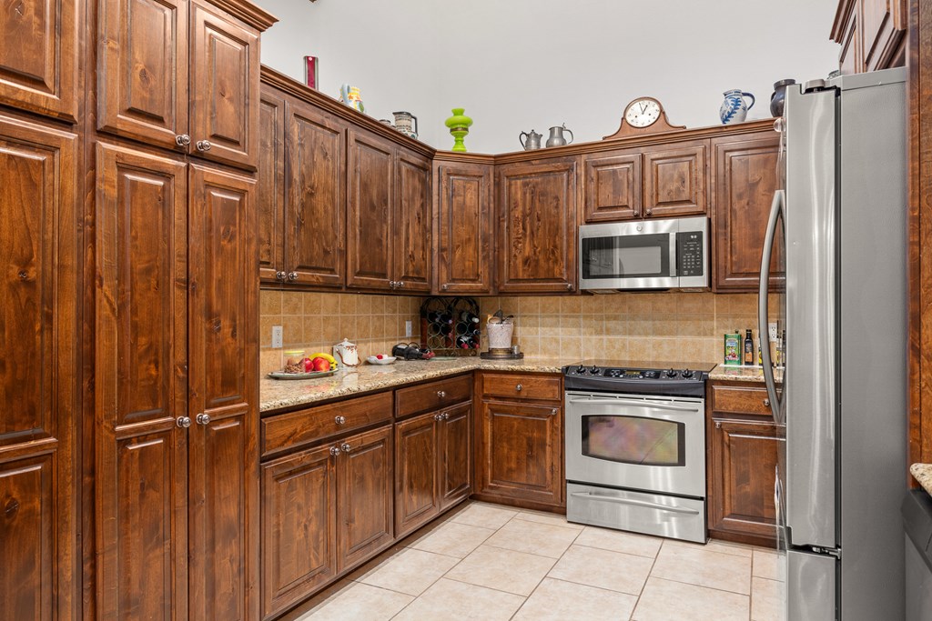 3801-12 Club House Road Kerrville, TX 78028 - Photo 7 of 23 a kitchen with stainless steel appliances granite countertop a refrigerator and a stove top oven